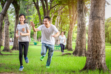 Happy family,asian little child girl or daughter playing tag game,running joyful with father,mother...