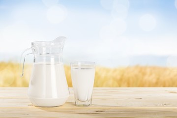 Glass jug of fresh milk  on background