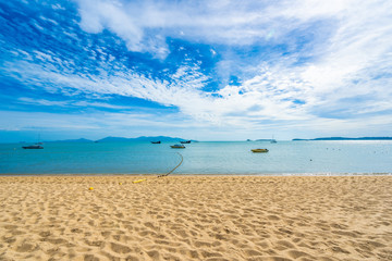 Beautiful tropical beach sea and ocean with coconut palm tree  and umbrella and chair on blue sky and white cloud