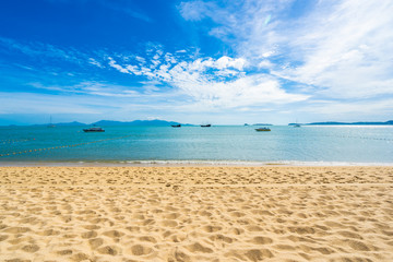 Beautiful tropical beach sea and ocean with coconut palm tree  and umbrella and chair on blue sky and white cloud