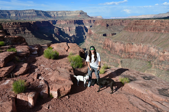Young woman with her two dogs at Toroweap Overlook in Grand Canyon National Park, Arizona.