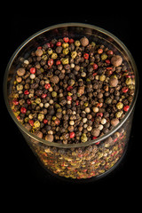 top view closeup assorted peppercorns in deep glass