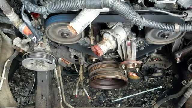 A stripped down timing belt section of a Nissan Frontier engine while it is started up.