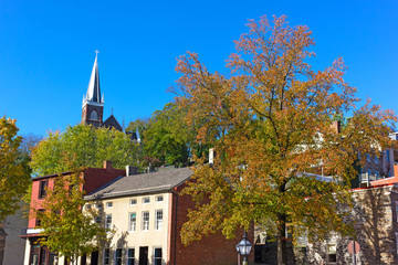 Harpers Ferry historic town in autumn, West Virginia, USA. A main town street and church on the hill.