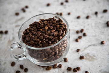 Glass cup of coffee and beans on granite background