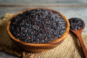 rice berry in wooden bowl with spoon on wooden table