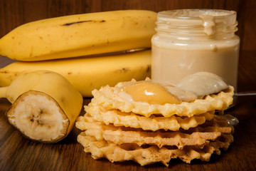 closeup tahini butter jar, bananas, and belgian waffles