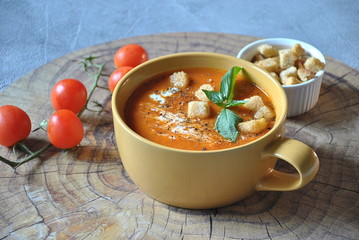 Tomato soup with croutons and fresh basil in a bowl