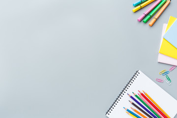 Fototapeta premium School supplies stationery, colour pencils, clips, paper on gray background, back to school concept with copy space for text, overhead, modern elementary education. flat lay, top view, mockup
