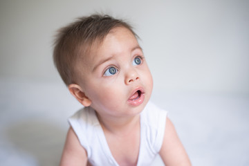 Blue-eyed baby in bed