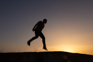 Fototapeta na wymiar silhouette of man jumping at sunrise