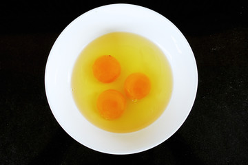 Top view of eggs in bowl on black background