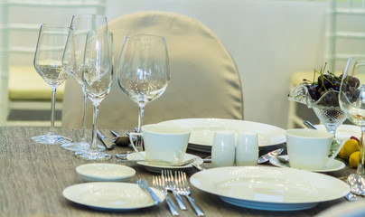 Christmas party dinner table setting with tableware and silverware and glasses set and Candlestick and flower in restaurant.