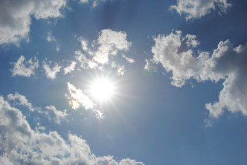 Sun on blue sky with clouds