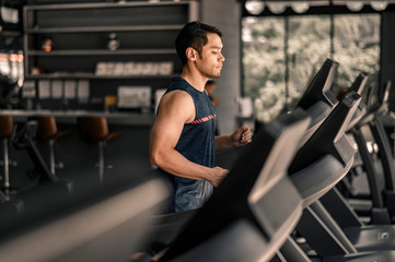 Fototapeta na wymiar man in sportswear running on treadmill at gym