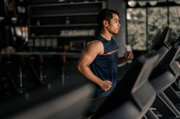 Fototapeta na wymiar man in sportswear running on treadmill at gym