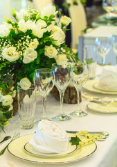 Luxury party dinner table setting with tableware and silverware and glasses set and Candlestick and flower in restaurant.