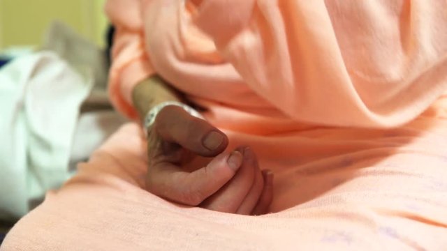 Elderly woman hospital gown IV hands