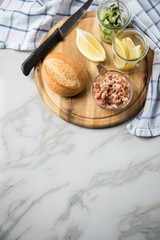 Norddeutsche Friesische Nordseekrabben in Glas Schale mit Brötchen, Gurkensalat und Zitronen auf Holz Brett