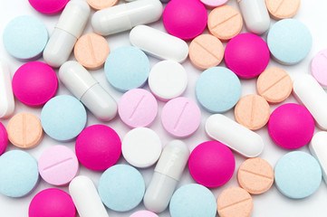 Different colorful pills or supplements for the treatment and health care on a white background.