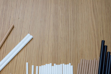 Bundle of paper straws white, brown and black in a wood table display background, great for environmental purpose