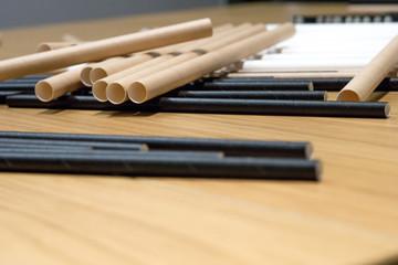 Bundle of paper straws white, brown and black in a wood table display background, great for environmental purpose