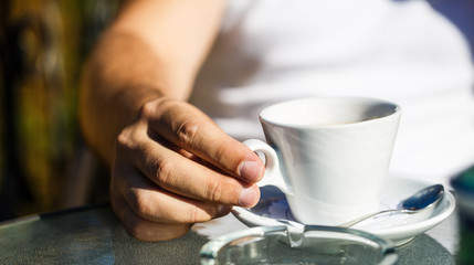 Fototapeta na wymiar Cup of coffee. Cappuccino and black espresso coffe cup. Coffee drink. Close up of a man hands holding a hot coffe cups. Coffe time. Hand of man hold coffee or coffe cup at cafe in the morning. Closeup