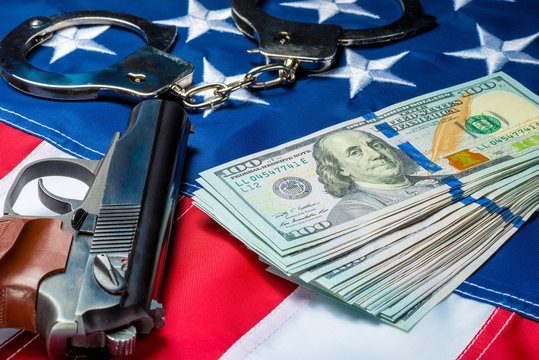 concept photo of seized money and weapons on the American flag - crime and punishment
