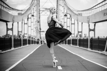 A gorgeous european young woman ballet dancer in city, inspiration for other people. Looks like princess have grace and body plastic dancing on outdoors