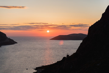 The sun setting over the Aegean sea on a beach in Kalymnos, Greece. 