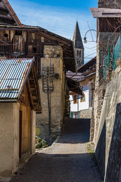 Bell tower of  Italian mountain chapel in Termenago - small village in Trentino, Italy. View from narrow alley.