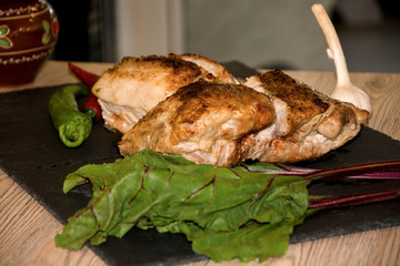 meat baked in the oven red pepper garlic black background wooden background