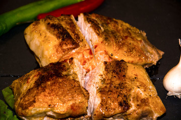 meat baked in the oven red pepper green pepper black background wooden background garlic