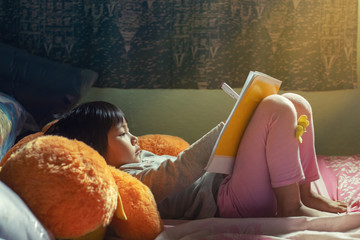 Profile of little Asian girl writing at home.
