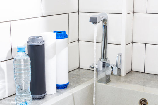 Water filter cartridge in the kitchen. Drinking water filtration system in the kitchen. Clean water at home.