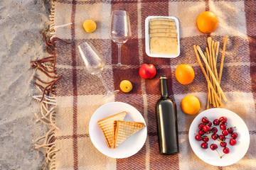Tasty food and drink for romantic picnic on beach