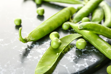 Tasty fresh peas on dark board, closeup