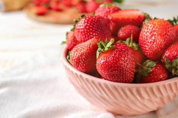 Bowl with ripe strawberry on table