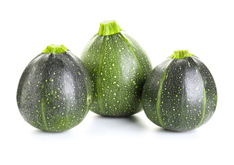 Fresh zucchini squashes on white background