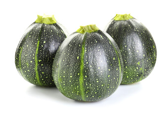 Fresh zucchini squashes on white background