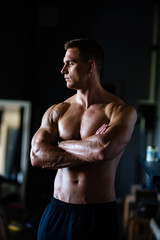 Naklejka na ściany i meble Strong, fit and sporty bodybuilder man over black background.