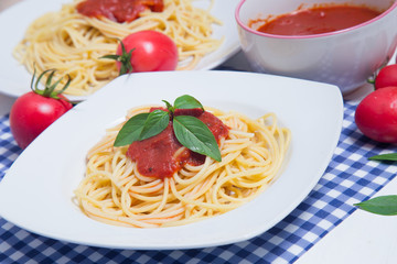 Spaghetti pasta with and tomato sauce on wood background