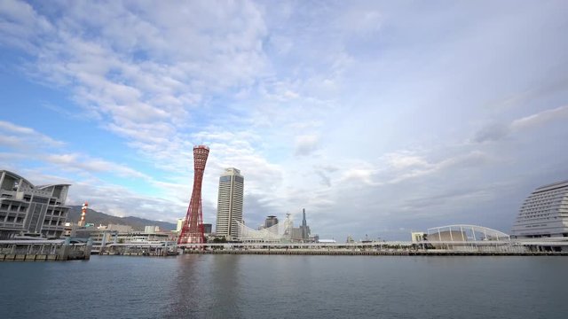 Panning shot of the Kobe City harbor from the sea under the blue skies and clouds
