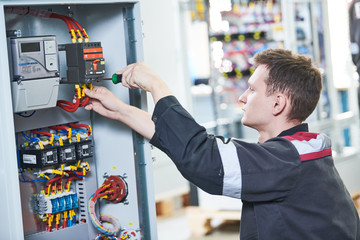 Electrician works with pliers in switchbox. current breaker installation
