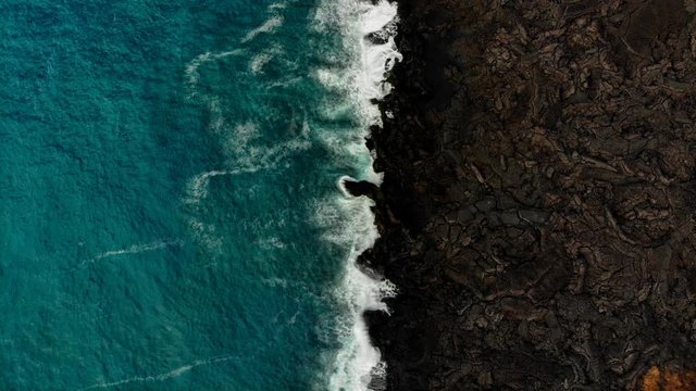 cinemagraph of the ocean against contrasting lava flow near Isaac hale park and kapoho that was recently destroyed by lava in 2018