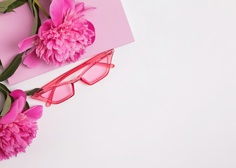 Summer composition with pink sunglasses and beautiful peonies