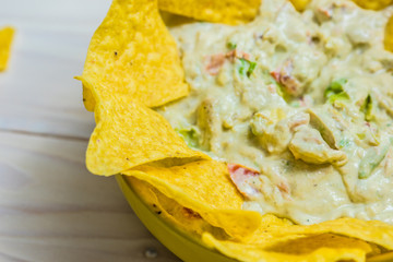 Tortilla chip made from corn tasty Tex-Mex food or snack on a wooden table.