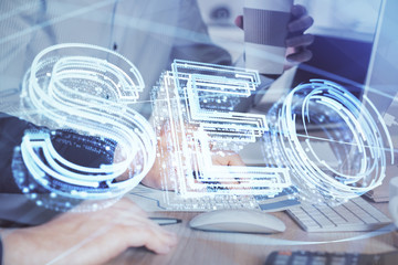 Multi exposure of seo icon with man working on computer on background. Concept of search engine optimization.