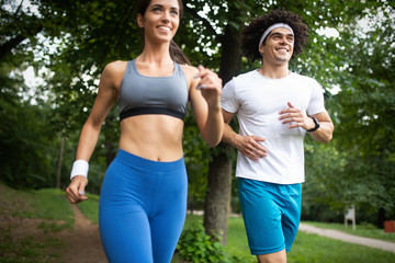 Happy young people jogging and exercising in nature