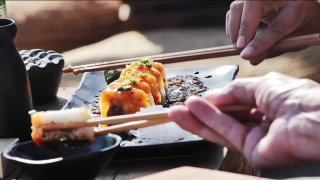 eating sushi in Asia with chopsticks